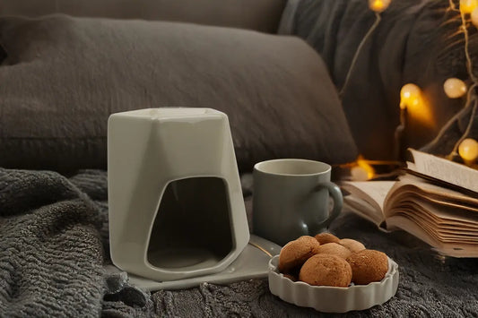 The rise of Gourmand scents, shown with a Alps wax burner, cosy setting and tasty snacks