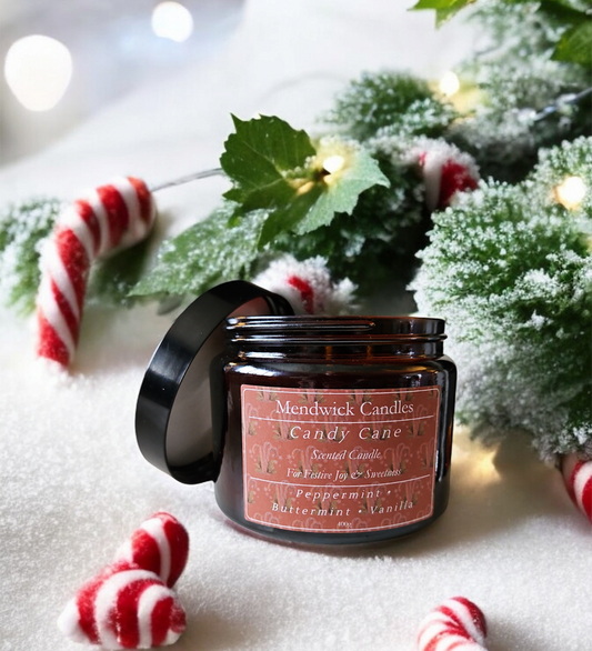 Lifestyle shot of Mendwick Candles Candy Cane 400g Scented Candle, shown with candy canes, frost and mint leaves