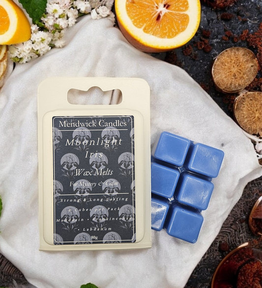 Moonlight Iris Wax Melts shown on a white cloth, surrounded by florals, mandarin and bergamot