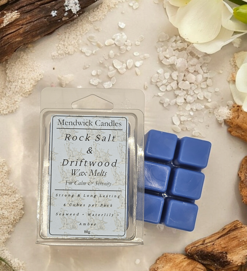 Rock salt& driftwood wax melts shown surrounded by rock salt, driftwood, petals and sand. 