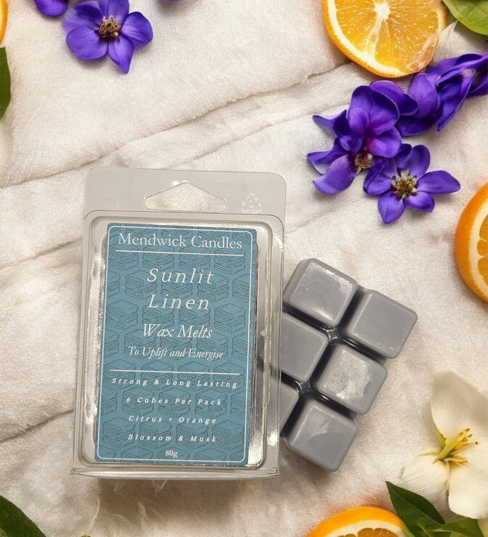 Sunlit Linen wax melts shown on soft towels surrounded by citrus fruit and  petals