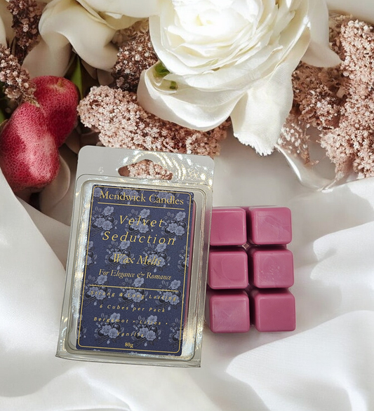 Velvet Seduction Scented Wax Melt shown, on a silk white cloth with flowers and plums